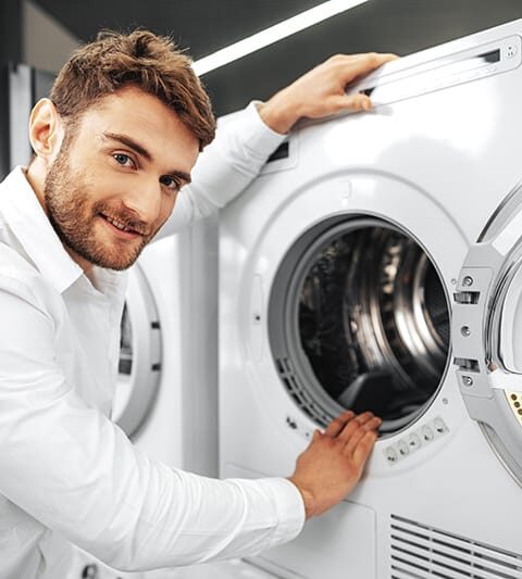young-man-choosing-new-washing-machine-household-appliances-store (1)