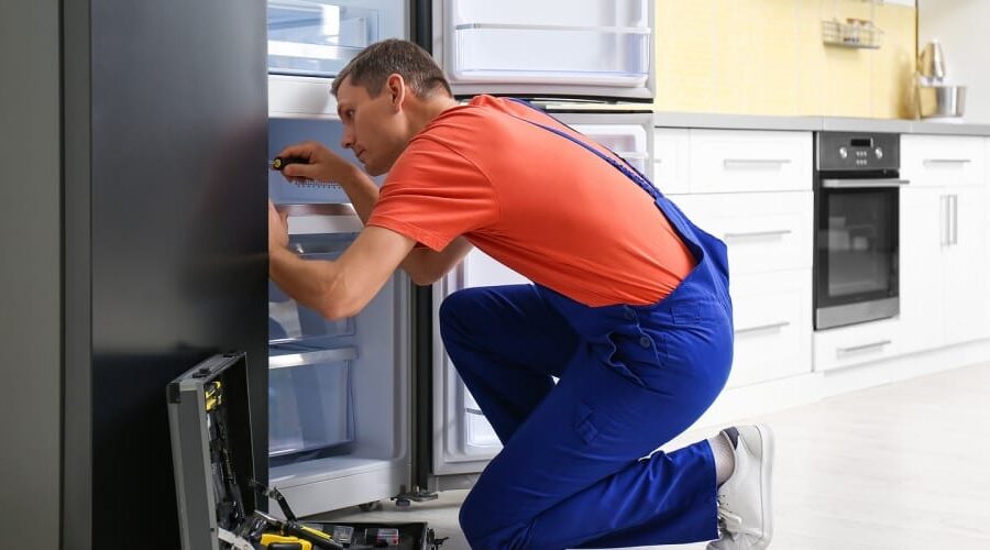 Male-Technician-With-Screwdriver-Repairing-Refrigerator-in-Kitchen-q5v0pz6tllqwast1r3fs70gy31g5eoirfh8gy5nslk